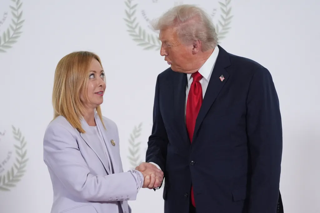 Donald Trump shakes hands with Giorgia Meloni.