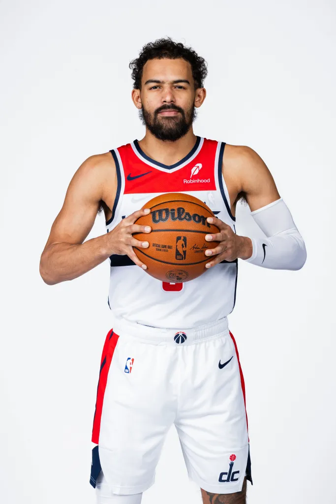 Trae Young of the Washington Wizards holding a basketball for a media day portrait.