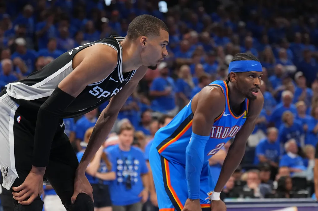 Victor Wembanyama and Shai Gilgeous-Alexander looking on during Game Seven of the NBA Western Conference Finals.