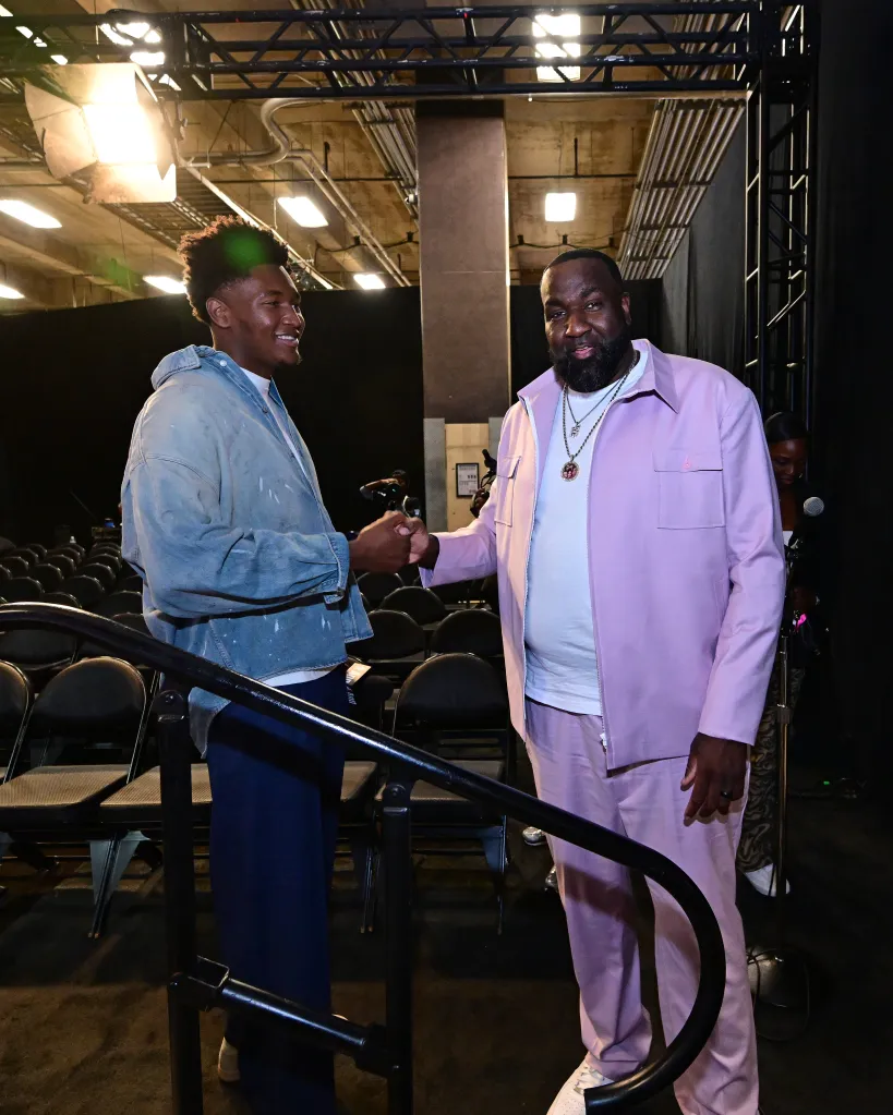 Derik Queen and Kendrick Perkins shake hands at an NBA game.