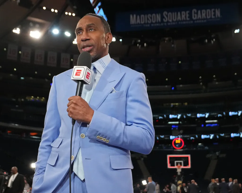 Stephen A. Smith speaking into an ESPN microphone in Madison Square Garden.