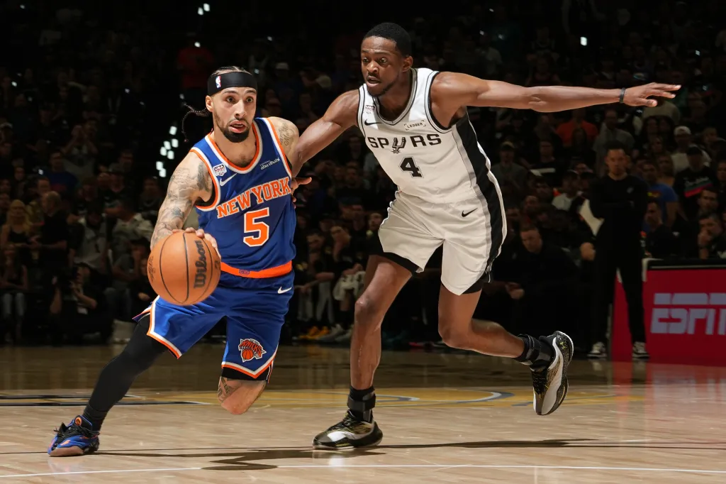 Jose Alvarado of the New York Knicks dribbles the ball against an opponent from the San Antonio Spurs.