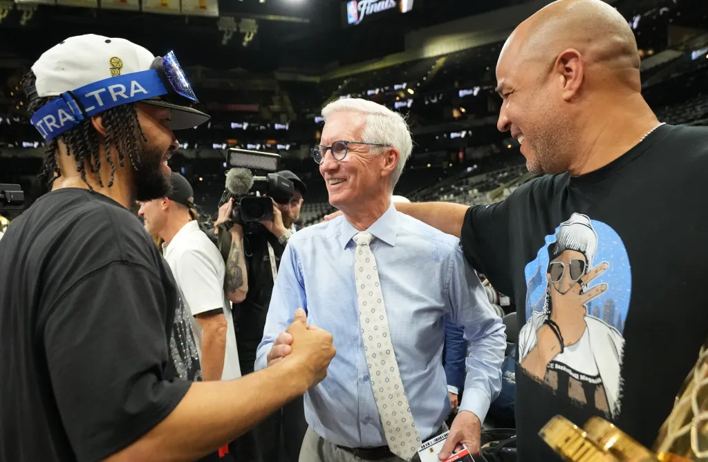 From left: Jalen Brunson, Mike Breen and Rick Brunson talk after the Knicks' NBA championship win on June 13, 2026.