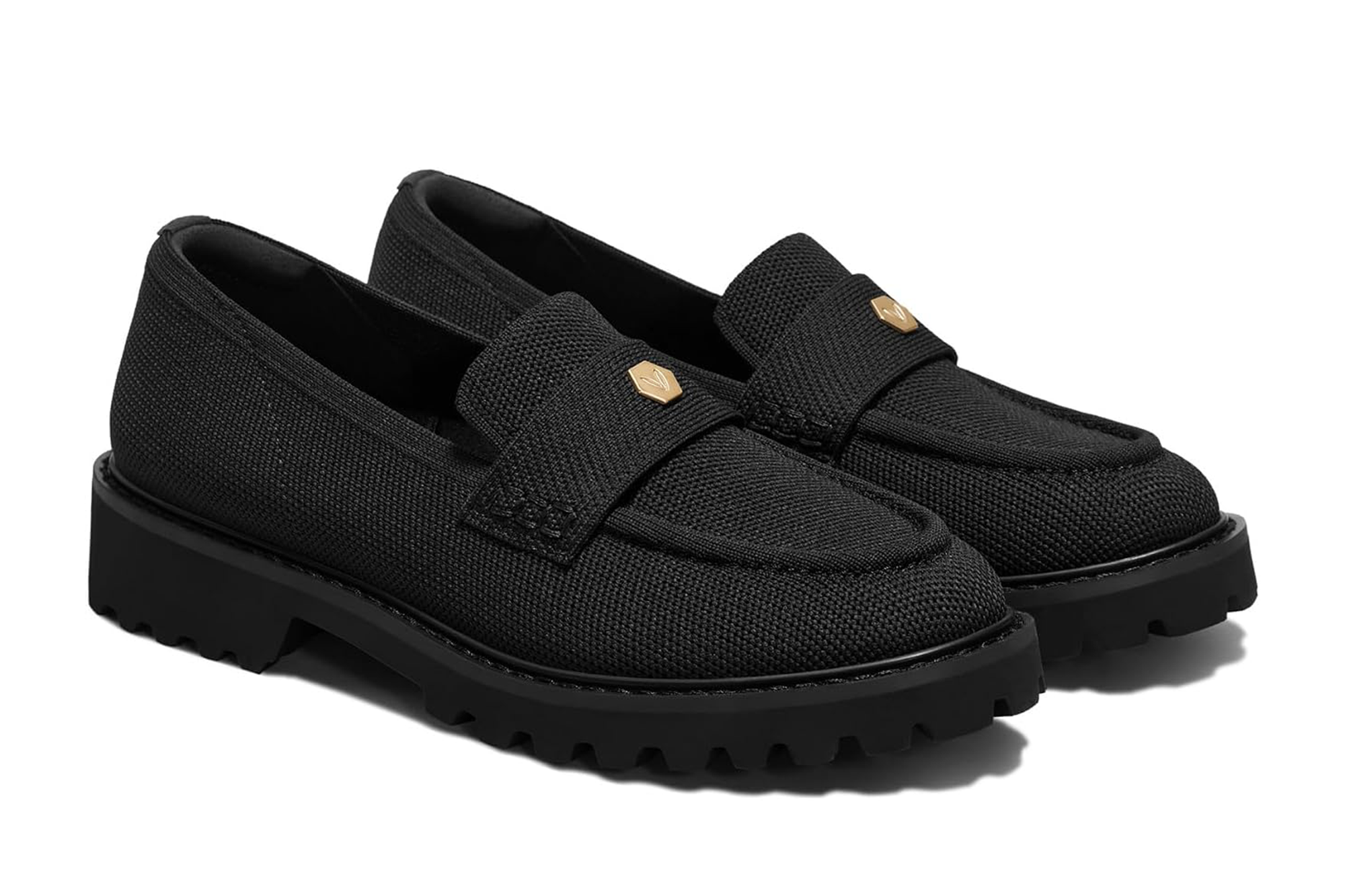 A pair of black woven loafers with gold hardware on the straps and thick lug soles.