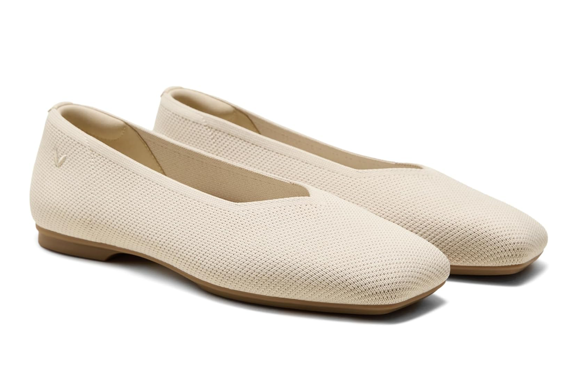 A pair of beige knitted ballet flats with brown soles.