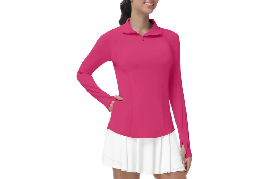 Woman wearing a hot pink long-sleeved athletic top and white tennis skirt.