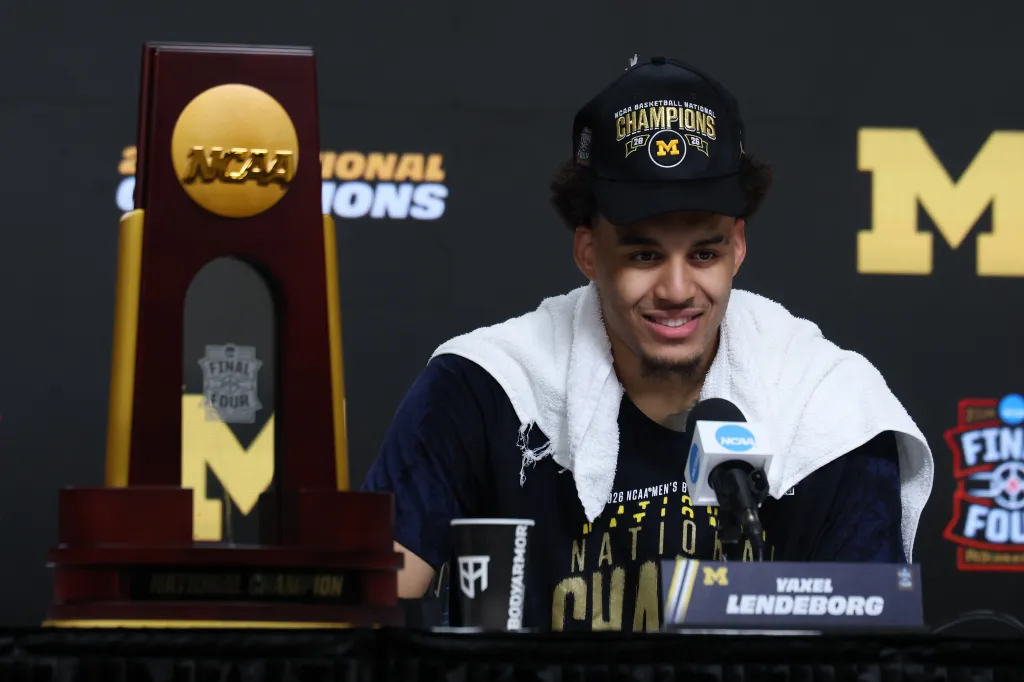 Yaxel Lendeborg of the Michigan Wolverines in a press conference with a National Championship trophy.