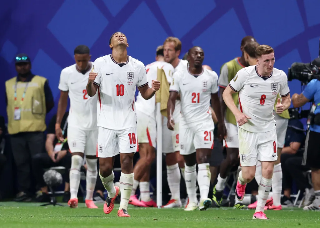 England's Jude Bellingham celebrating a goal with Harry Kane and other teammates.