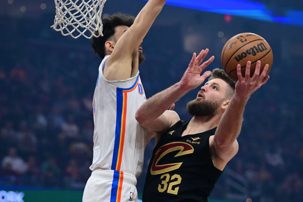 Cleveland Cavaliers forward Dean Wade (32) goes to the basket against Oklahoma City Thunder center Chet Holmgren in the first half of an NBA basketball game, Jan. 19, 2026, in Cleveland.