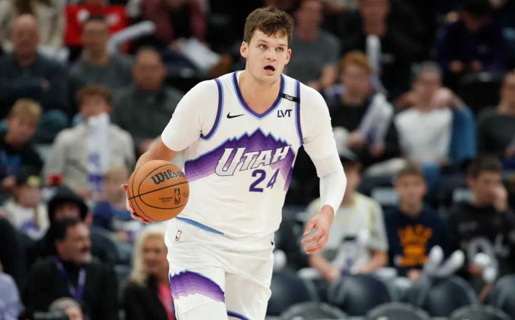 Walker Kessler in a Utah Jazz uniform holding a basketball.