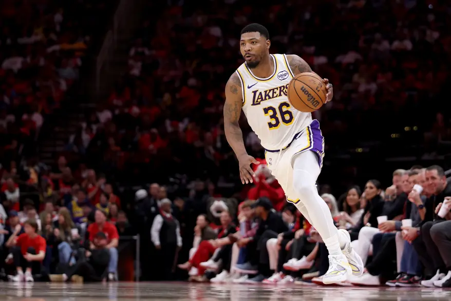 Basketball player Marcus Smart in a Lakers uniform dribbles the ball.