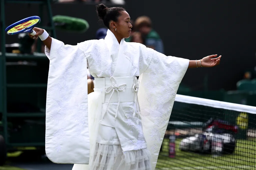 Naomi Osaka warms up in a white kimono with embroidered cranes and flowers.