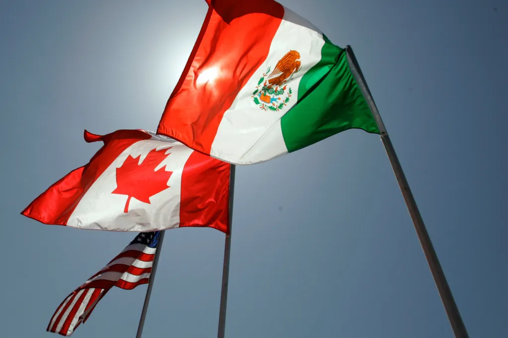 National flags of the US, Canada, and Mexico flying in the breeze.