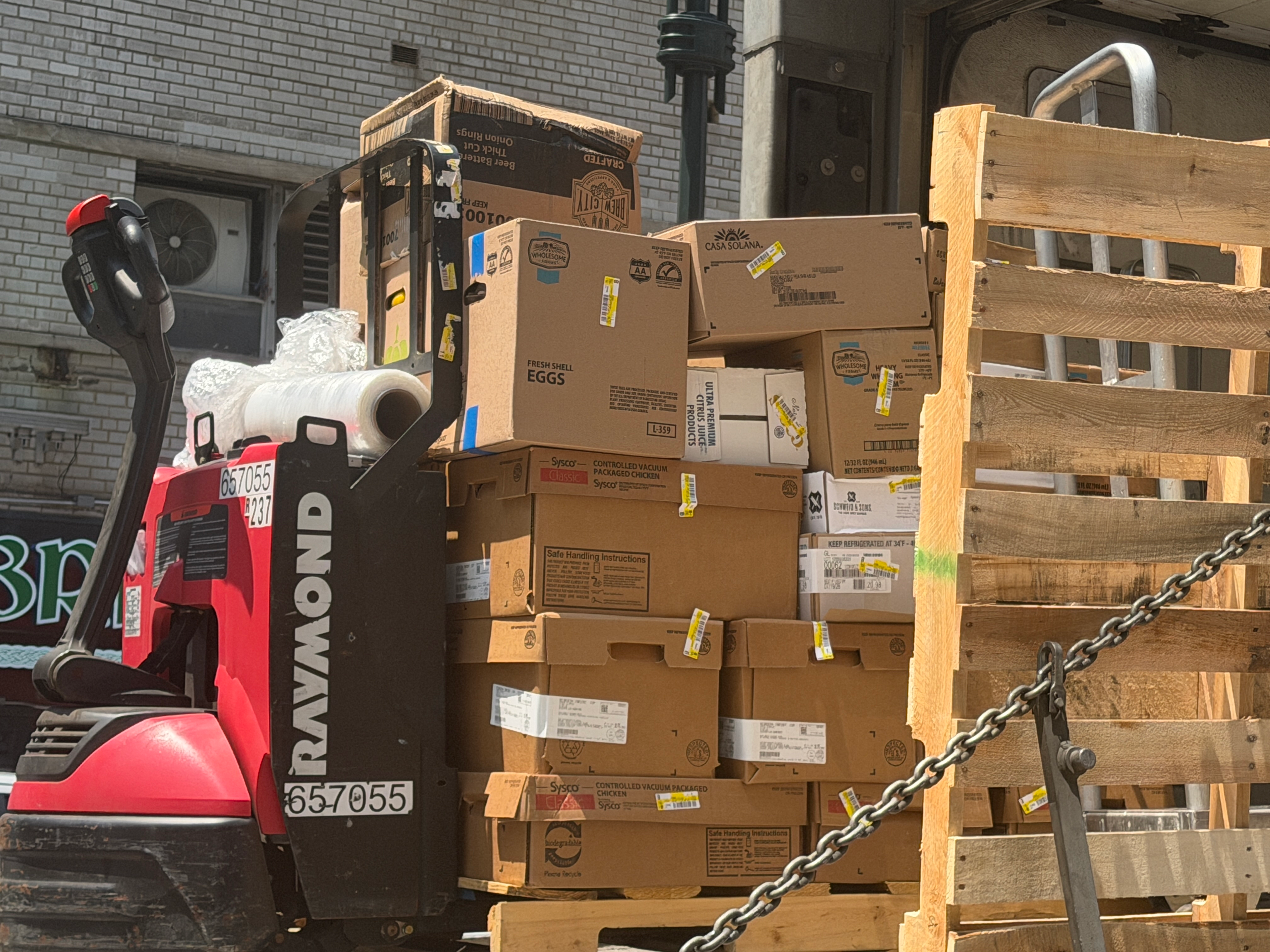 Food delivery boxes on a pallet jack are unloaded from a truck at Madison Square Garden.